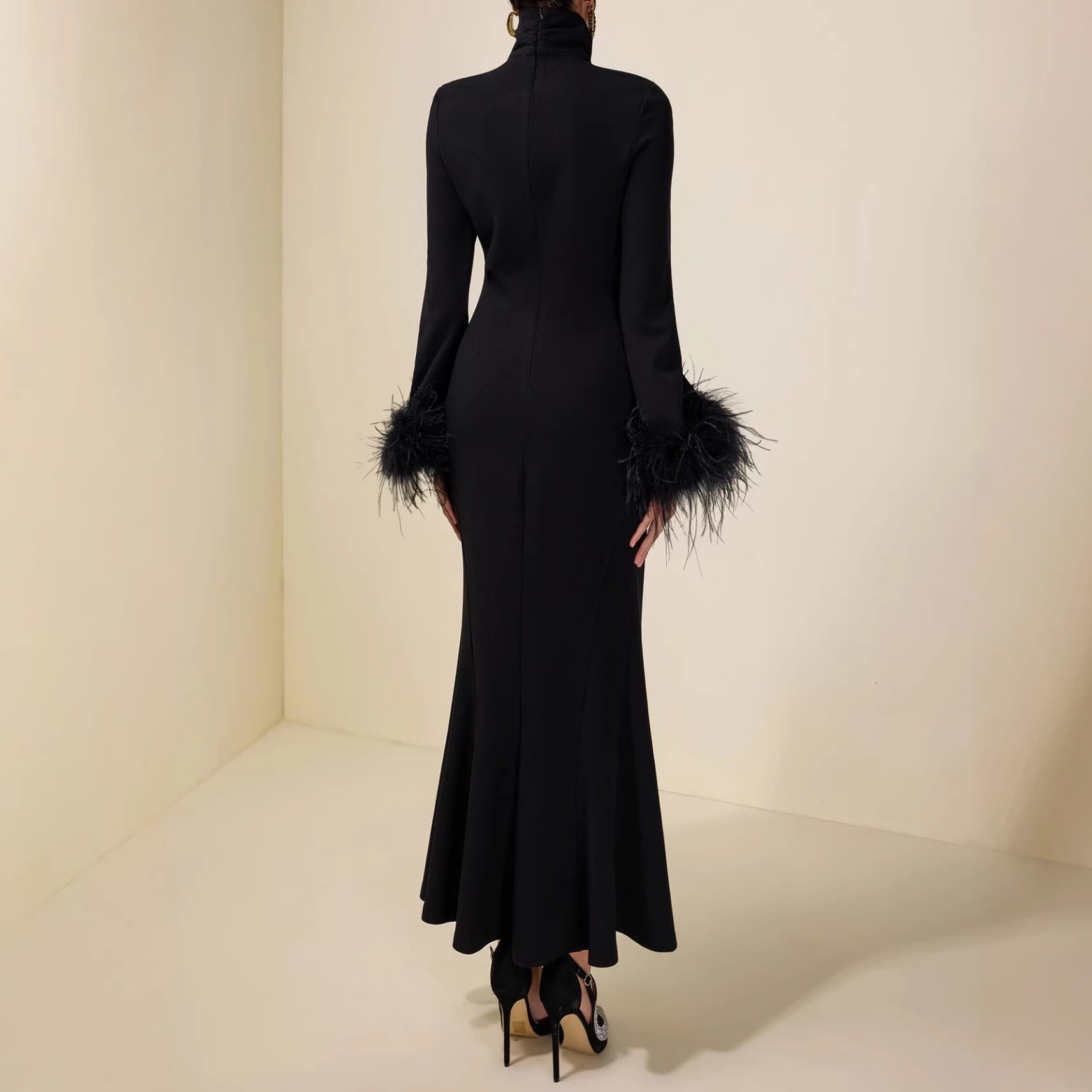 High-necked, fitted bodice, feathered cuffs, pure black, full-skirted, long dress with a flattering silhouette